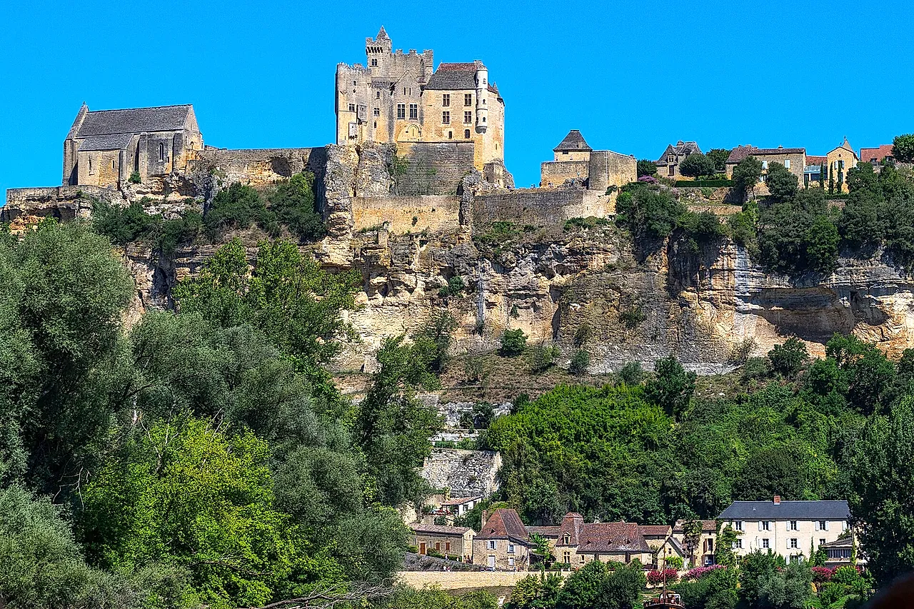 Château de Beynac perched on its limestone cliff above the Dordogne valley under a deep blue sky